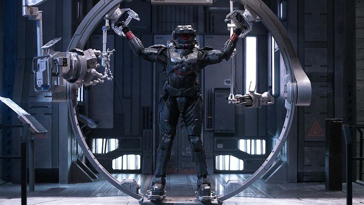 Riz in Spartan-Rüstung zwischen Roboterarmen in einer Szene aus Halo