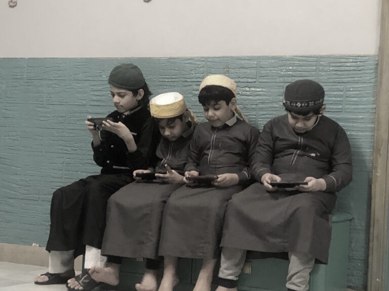 Kinder spielen Videospiele auf einem Smartphone – Symbolbild zu Chinas Online-Gaming-Beschränkungen für Minderjährige