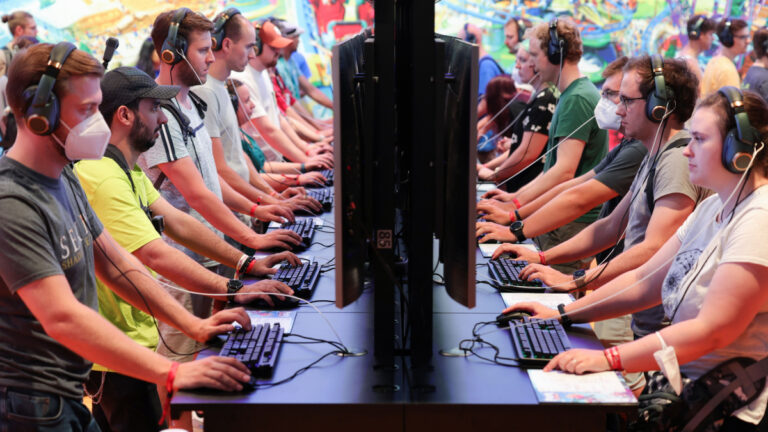 Besucherinnen und Besucher an Messeständen der gamescom 2022
