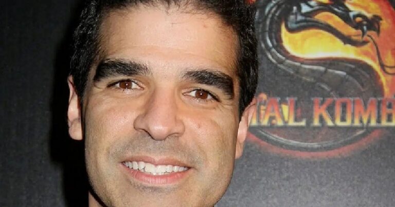 Mortal-Kombat-Miterfinder Ed Boon vor einem Mortal-Kombat-Motiv