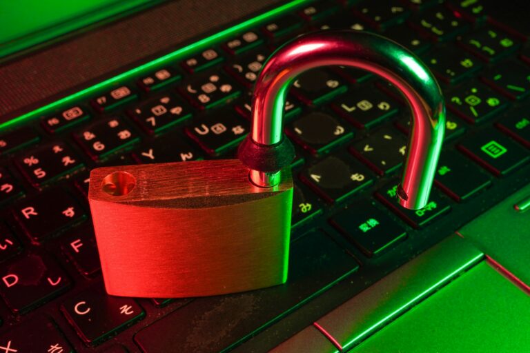 Geöffnetes Vorhängeschloss auf einer Laptop-Tastatur als Symbol für unzureichende Gerätesicherung