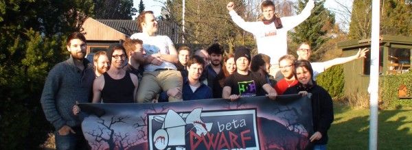 Mitglieder des BetaDwarf-Teams mit einem Banner des Studios