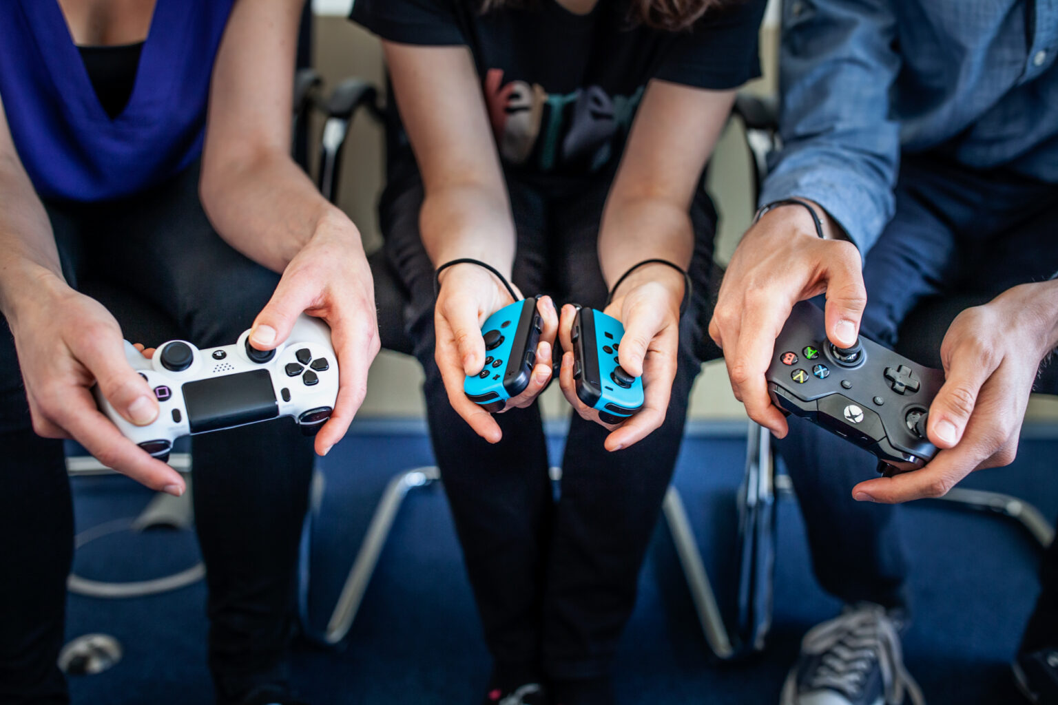 Personen mit PlayStation-, Nintendo-Switch- und Xbox-Controllern, Symbolbild - Bild: USK