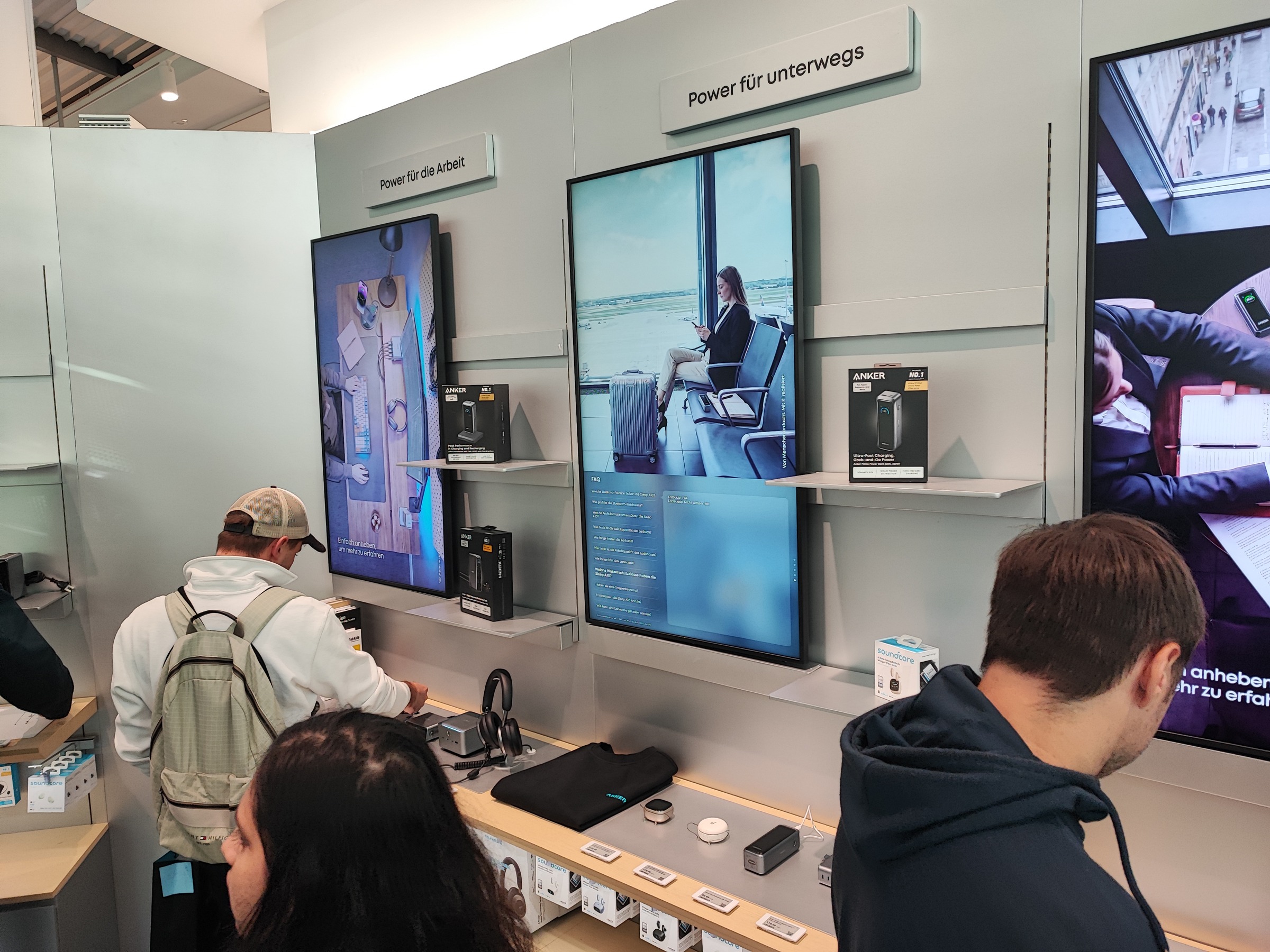 Besucher an den Präsentationstischen für Arbeit und unterwegs im Berliner Anker-Store