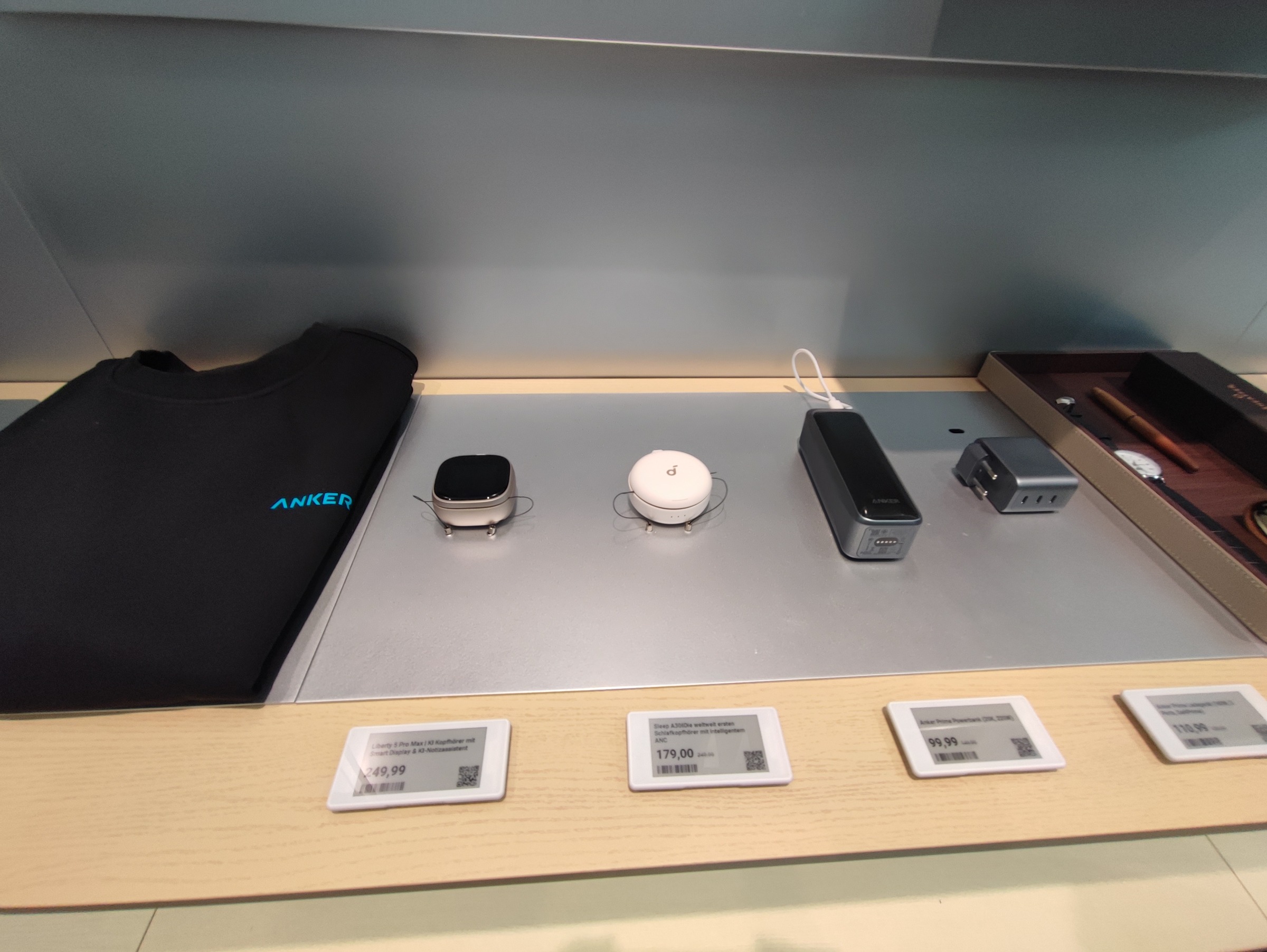 Zwei In-Ear-Ladecases, eine Powerbank und ein Ladegerät auf einem Tisch im Anker-Store