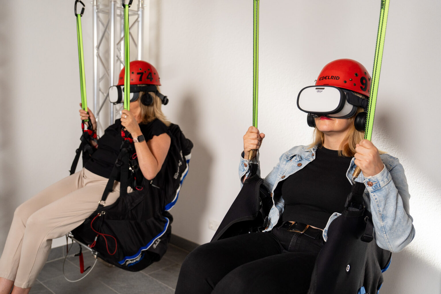 Besucherinnen mit VR-Brillen in aufgehängten Sitzen in der Triberg VR-Arena - Bild: Triberg VR-Arena