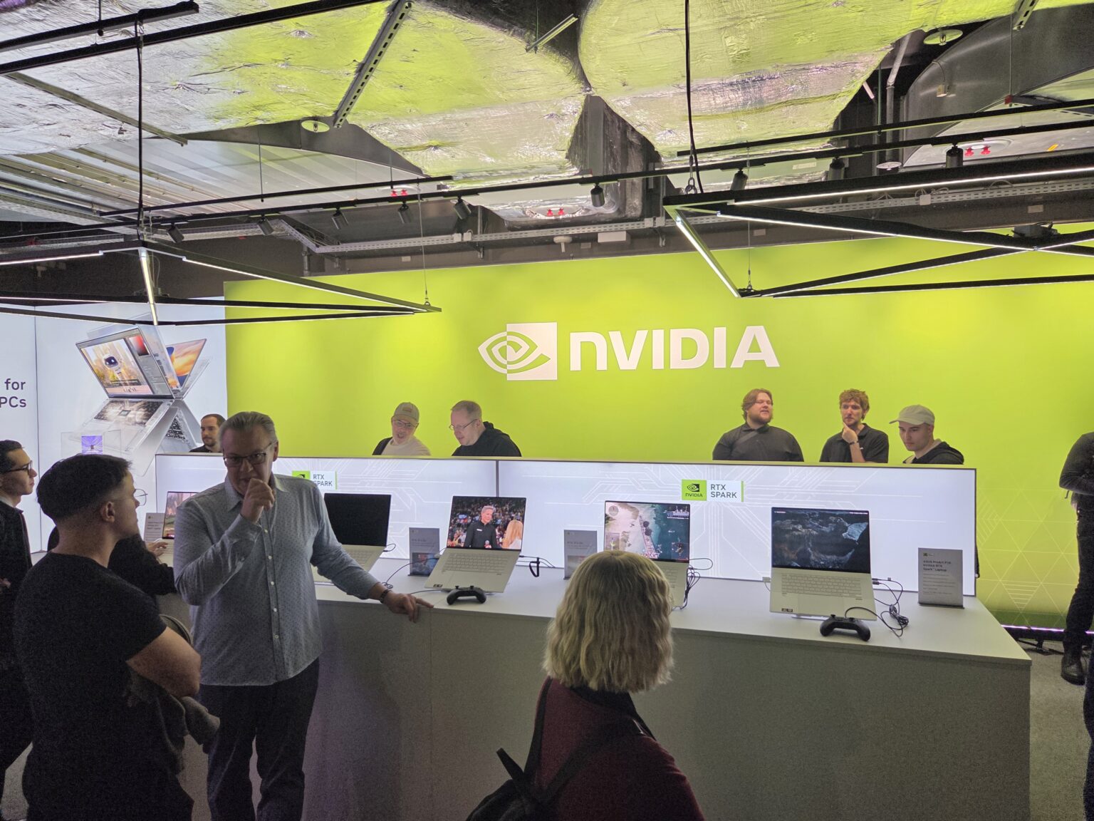 Besucher vor den RTX-Spark-Demostationen im grün beleuchteten XPERION Berlin
